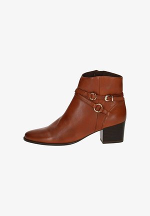 Bottine en cuir marron avec un bout pointu et un talon bloc, comportant deux sangles décoratives avec des accents métalliques ronds. Texture lisse.
