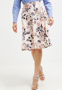 Knee-length floral skirt in cream, featuring pink and navy flowers. Elastic waist, lightweight fabric with a smooth texture, flowing design.