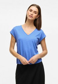 Niebieski t-shirt w kształcie v z krótkim rękawem, wykonany z teksturowanej tkaniny, połączony z czarną spódnicą. Prosty design, swobodny krój.