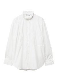 White long-sleeve shirt with a mandarin collar, buttoned front, and two side pockets. Smooth cotton fabric with a relaxed fit and rounded hem.
