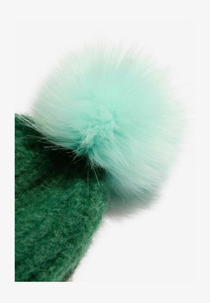 Zelena pletena kapa s mekanim, okruglim pom-pomom u boji mente na vrhu; ima teksturiranu, pahuljastu tkaninu i strukturirani oblik.