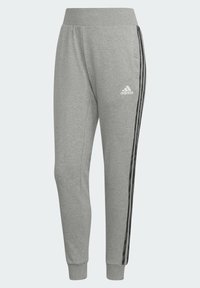 Grå sweatpants i mjukt tyg, med ett ribbat midjeband, svarta sidostripes och en liten vit logotyp. Fitted muddar vid anklarna.