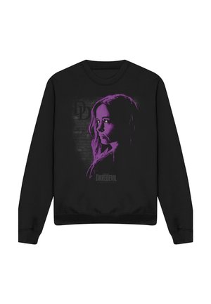 Schwarzes Sweatshirt mit lila Schablonen-Porträt einer Frau, „DD“-Logo und „Daredevil“-Schriftzug vor einer Ziegelsteinwand.