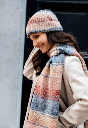 Knit beanie and scarf set, featuring a multicolored pattern in warm hues of orange, blue, and cream with a textured finish.