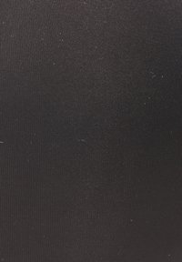 Crni sintetički materijal s glatkom, teksturiranom površinom, s blagim rebrastim uzorkom i malim mrljama kroz cijelu površinu.