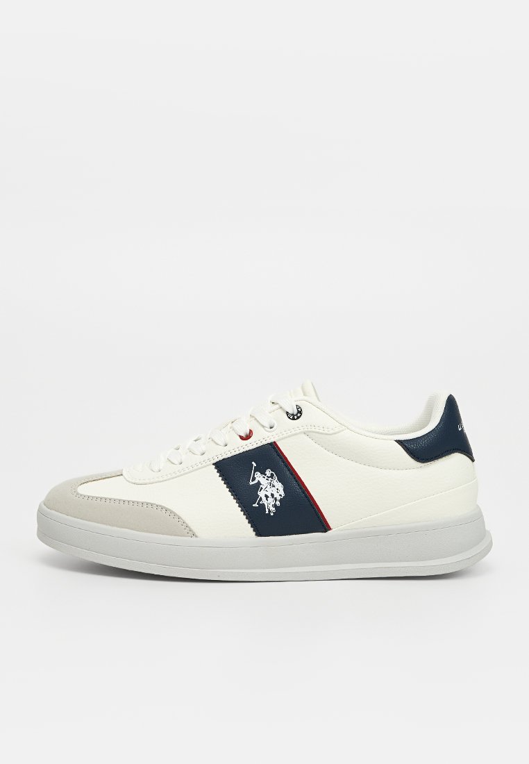 Zapatilla de cuero blanca con acentos en azul marino y rojo, con una puntera de ante, cordones en la parte frontal y un logo en el lateral.
