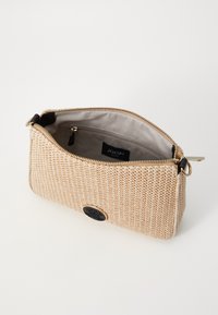 Borsa in tessuto intrecciato beige con una superficie liscia, una cerniera dorata e un'etichetta nera. L'interno presenta una fodera beige e una tasca con zip.