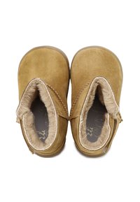 Botas de tobillo de ante en un cálido tono marrón claro, con un suave forro de pelo sintético y costuras reforzadas, que presentan bordes curvados y un diseño de puntera redondeada.