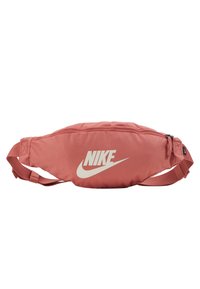 Nike bumbag i dammig ros med en slät yta, som har en framträdande vit logotyp, dragkedjestängning och justerbar rem.