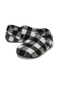 Pantofole a quadri in bianco e nero con una texture morbida e pelosa, forma arrotondata e suola in gomma nera. Presentano un logo decorativo sul lato.