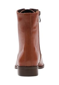 Stivaletto in pelle marrone con finitura liscia, cerniera laterale e tacco basso impilato; dettagli di cucitura lungo i lati.