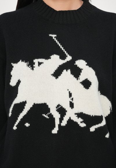 Črni pleteni pulover z veliko belo polo sceno s konjem in jezdecem. Oblikovanje je pikselirano za teksturiran videz.