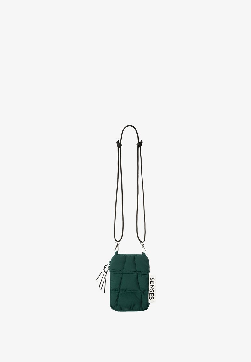 Green padded crossbody bag with a zipper, adjustable black cord strap, and a white tag labeled "SENSES." Textured surface with quilted pattern.