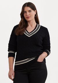Μαύρο πουλόβερ με πλέξιμο σε σχοινί και V-λαιμό, με άσπρες ρίγες στις μανσέτες και τον λαιμό. Διαθέτει μακριά μανίκια και χαλαρή εφαρμογή.