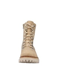 Bota de tobillo de ante beige con una suela blanca resistente, caracterizada por ojales metálicos, cordones texturizados y una cremallera lateral para un fácil acceso.