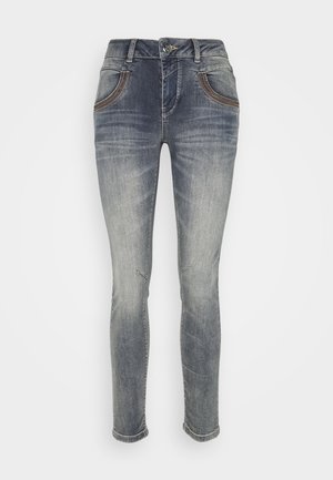 Jean denim gris coupe slim avec un effet délavé, fermeture avant par bouton et zip, et poches avant incurvées avec surpiqûres contrastantes.