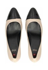 Béžové kožené baletky s lesklou černou špičkou. Mají polstrovanou černou stélku a malý červený akcent na podpatku.