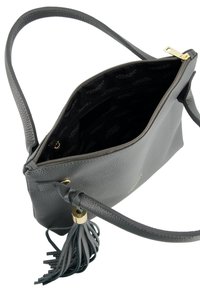 Graue Lederhandtasche mit strukturiertem Finish, goldenen Beschlägen und einem Quastenakzent. Das Innere ist mit schwarzem Stoff ausgekleidet, der ein Logo-Muster zeigt.