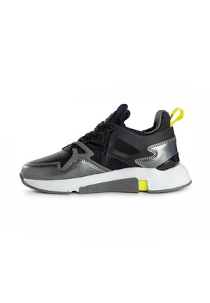 Scarpa da ginnastica nera e grigia con tomaia testurizzata, dettagli metallici e suola bianca con un inserto giallo sul tallone e battistrada decorato.