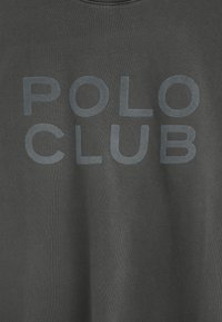 Sudadera de color gris oscuro con una textura suave y un gran texto impreso en un tono ligeramente más claro que dice "POLO CLUB".