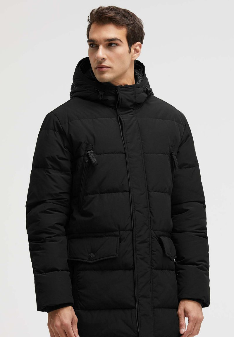Schwarze Steppjacke mit Kapuze, durchgängigen Brusttaschen mit Reißverschluss und einer geknöpften Klapptasche, mit einem gesteppten Muster und geradem Schnitt.