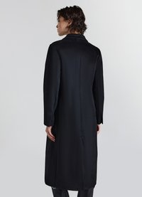 Langer schwarzer Mantel aus glattem Stoff, mit geradem Schnitt, voll langen Ärmeln und klassischem Kragen. Einfaches Design ohne sichtbare Muster.