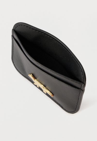 Μαύρος δερμάτινος κάτοχος καρτών με λεία υφή, με χρυσή μεταλλική λεπτομέρεια στο μπροστινό μέρος. Συμπαγής σχεδίαση με ανοιχτή τσέπη.