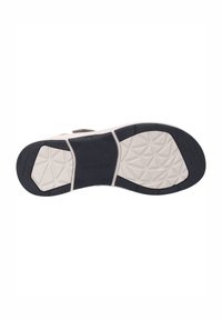 Suola di scarpa con una superficie in gomma nera testurizzata, caratterizzata da un motivo geometrico e una soletta bianca a contrasto. Branding visibile sulla suola.