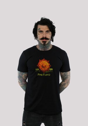 Black cotton t-shirt featuring a colorful sun graphic with detailed patterns and the text "PINK FLOYD" below. Short sleeves, casual fit.