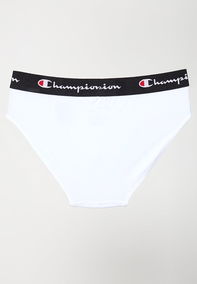 Białe bawełniane majtki z czarnym pasem zawierającym logo "Champion" w białym, kursywowym piśmie oraz czerwonymi akcentami. Gładka tekstura.