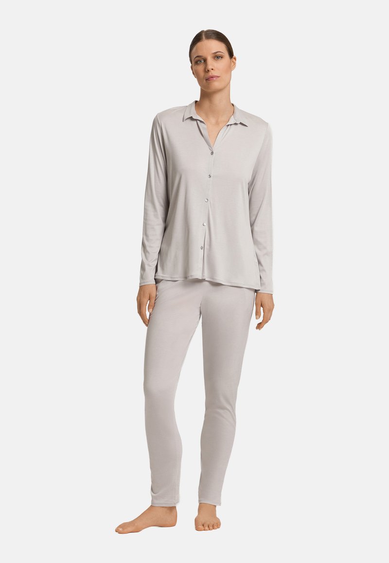 Lichtgrijze pyjama set bestaande uit een knoopsluiting met lange mouwen en een aangesloten broek, beide gemaakt van zachte, rekbare stof met een gladde textuur.