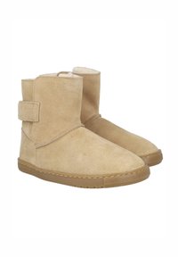 Botines de ante beige con una correa ajustable, punta redondeada, forro interior suave y suela de goma en contraste.