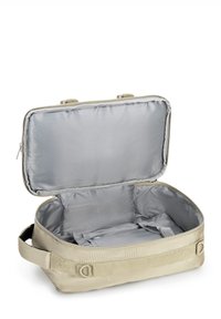 Béžová cestovní taška s prostorným vnitřkem, měkkým šedým podšívkou, zipovým uzávěrem a dvěma rukojeťmi, navržená pro organizaci a snadný přístup.