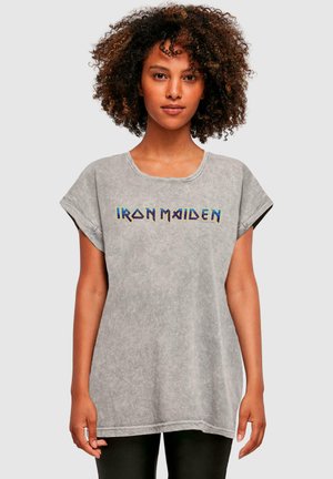 Hall haruline T-särk, millel on ümmargune kaelus ja rullitud lühikesed varrukad. Ees on mitmevärviline "IRON MAIDEN" tekst. Pehme tekstuur.