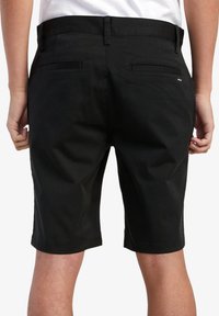 Pantalones cortos negros de un tejido suave, con una cinturilla plana y dos bolsillos traseros, con un dobladillo que llega justo por encima de la rodilla.