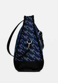 Borsa di tessuto blu con accenti scuri, forma triangolare, parte anteriore a motivo e fondo in pelle a contrasto. Include un gancio in metallo e una tracolla.