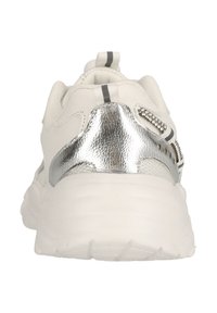 Weißer Sneaker mit einem strukturierten silbernen Fersenakzent, der graue Streifen und einen gepolsterten Kragen aufweist. Die Sohle ist dick und leicht gewölbt.