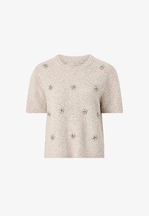 Korte mouwen, lichtbeige trui gemaakt van zacht materiaal, met zilveren bloemversieringen gelijkmatig verdeeld over de voorkant.