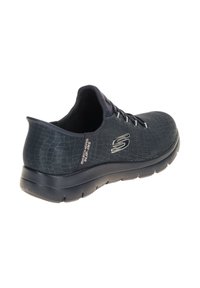 Sneaker slip-on Skechers di colore grigio scuro con tomaia in maglia, suola nera e logo sul lato e sul tallone.