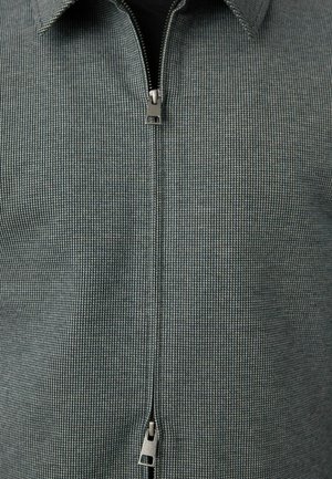 Short-sleeve, zip-up shirt in a textured gray pattern with a classic collar; features a metallic zipper and subtle check design.
