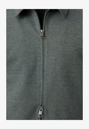Camicia a maniche corte, con chiusura a zip, in un motivo grigio testurizzato con colletto classico; presenta una zip metallica e un sottile design a quadretti.