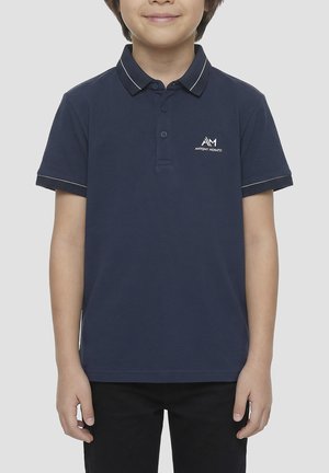 Niño con polo azul marino con ribete blanco en el cuello y las mangas, y un pequeño logo de Antony Morato en el pecho.