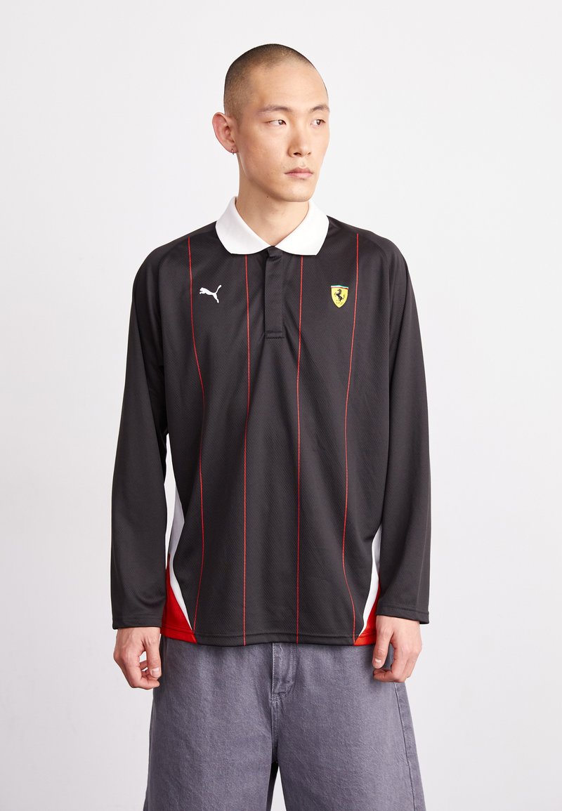 Juodas polo marškinėliai ilgomis rankovėmis su raudonomis vertikaliomis juostelėmis, balta apykakle, Puma logotipu ir Ferrari emblema krūtinėje. Lengva, tekstūruota medžiaga.