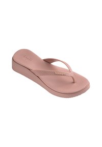 Vaaleanpunaiset kumiset flip-flop-sandaalit, joissa on teksturoitu pohja, kapeat hihnat ja matala pohja. Hihnassa on "havaianas"-brändäys.