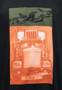 Εμπρόσθια όψη ενός μεγάλου ημιφορτηγού σε πορτοκαλί χρώμα κάτω από μια παχιά μαύρη αλυσίδα σε πράσινο φόντο, όλα τοποθετημένα σε μαύρο φόντο.