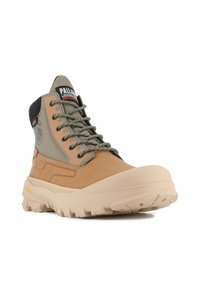 Waterproof hiking boot featuring tan leather and gray textile upper, prominent rubber sole, and durable laces with metal eyelets.