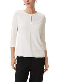 Weißes Blusenshirt mit einem runden Ausschnitt und einem kleinen Schlüsselloch-Detail an der Vorderseite. Verfügt über Dreiviertelärmel und einen lockeren Schnitt.