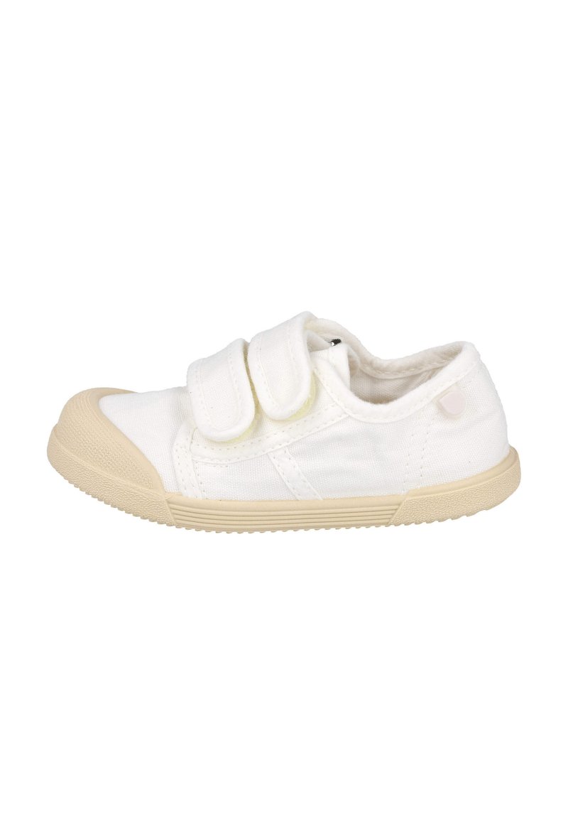 Zapatilla de lona blanca con suela de goma beige, que presenta dos correas de Velcro y una puntera redondeada. Tejido texturizado con detalles de costura simples.