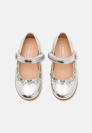 Silberne Mary Jane Schuhe mit glänzender Oberfläche, verziert mit metallischen Blumenakzenten und einem Schnallenriemen. Geschmeidige Textur, runde Zehenform.