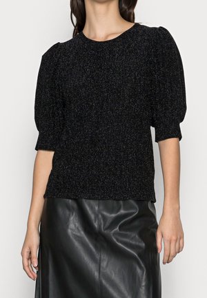 Black knitted top with short puff sleeves, textured fabric, and subtle shimmer. Paired with a sleek black leather skirt.